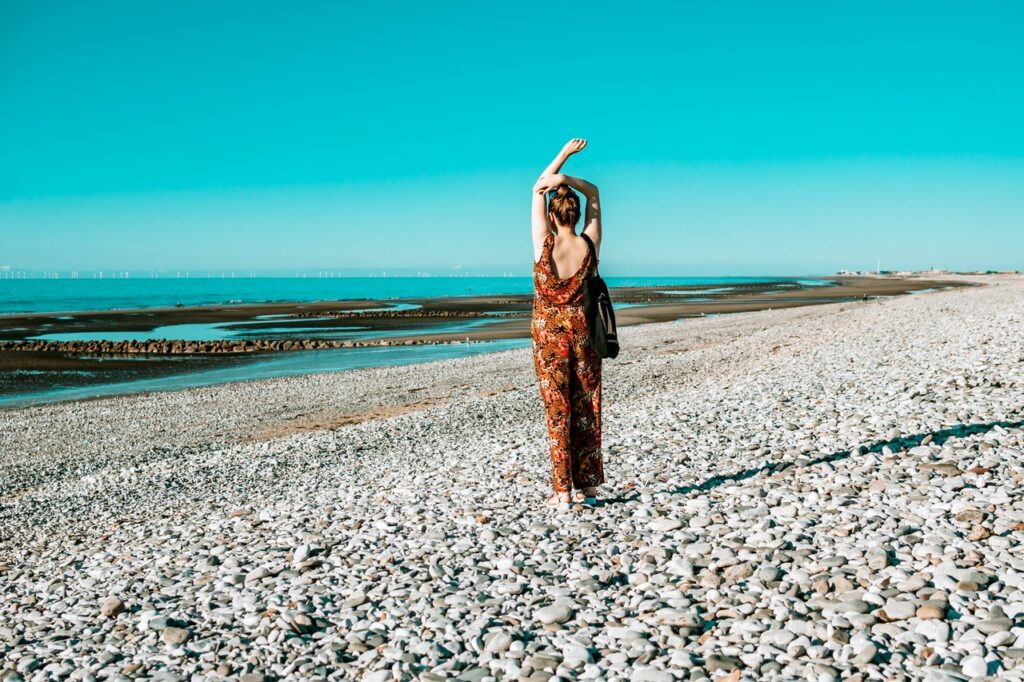 woman with her back to the camera looking at the turquoise sea